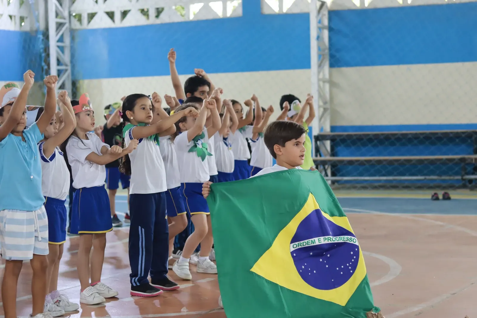Estudantes em apresentação com símbolos do Brasil